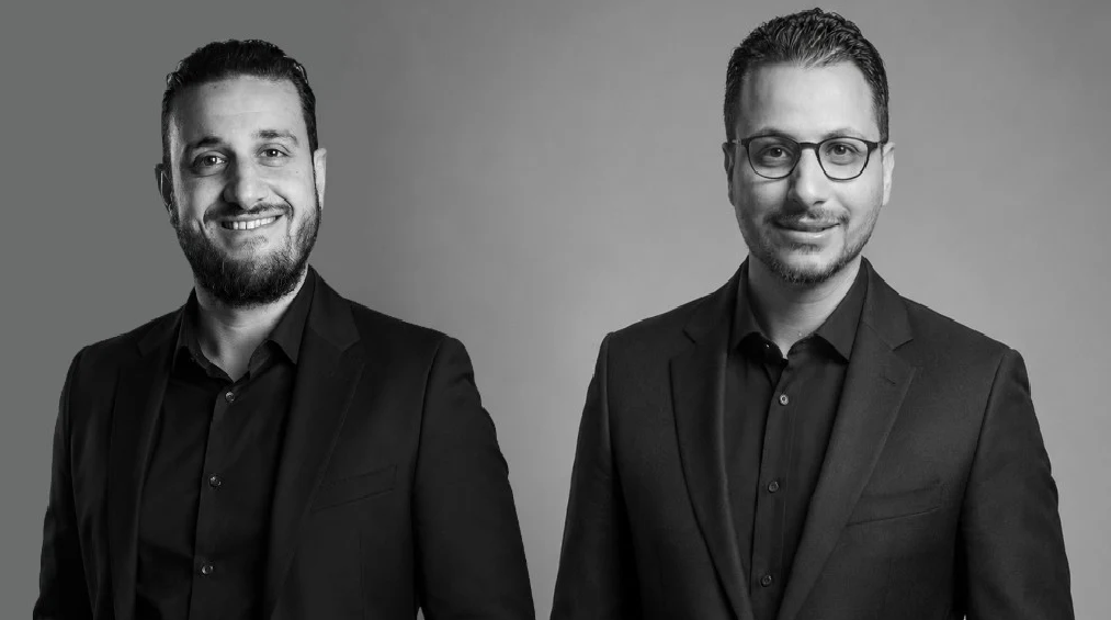 Black and white portrait of two founders in business attire